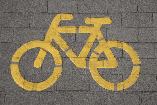 Painted yellow bicycle icon engraved on a wall.