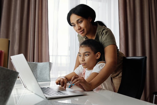 Mother and daughter watching something an a laptop