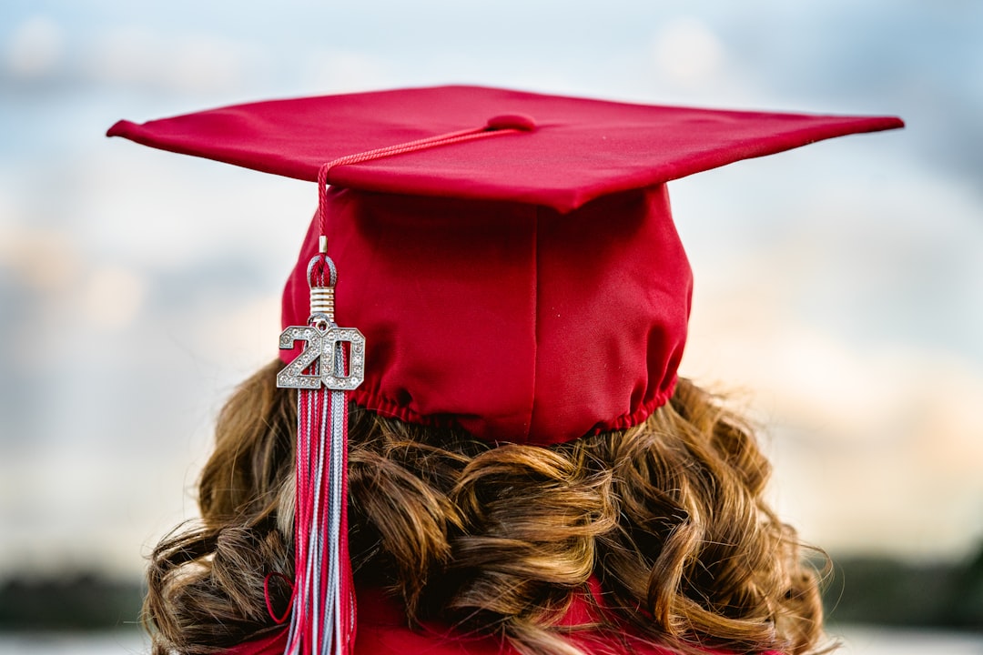 Student graduate on a river looking off into the sky.
