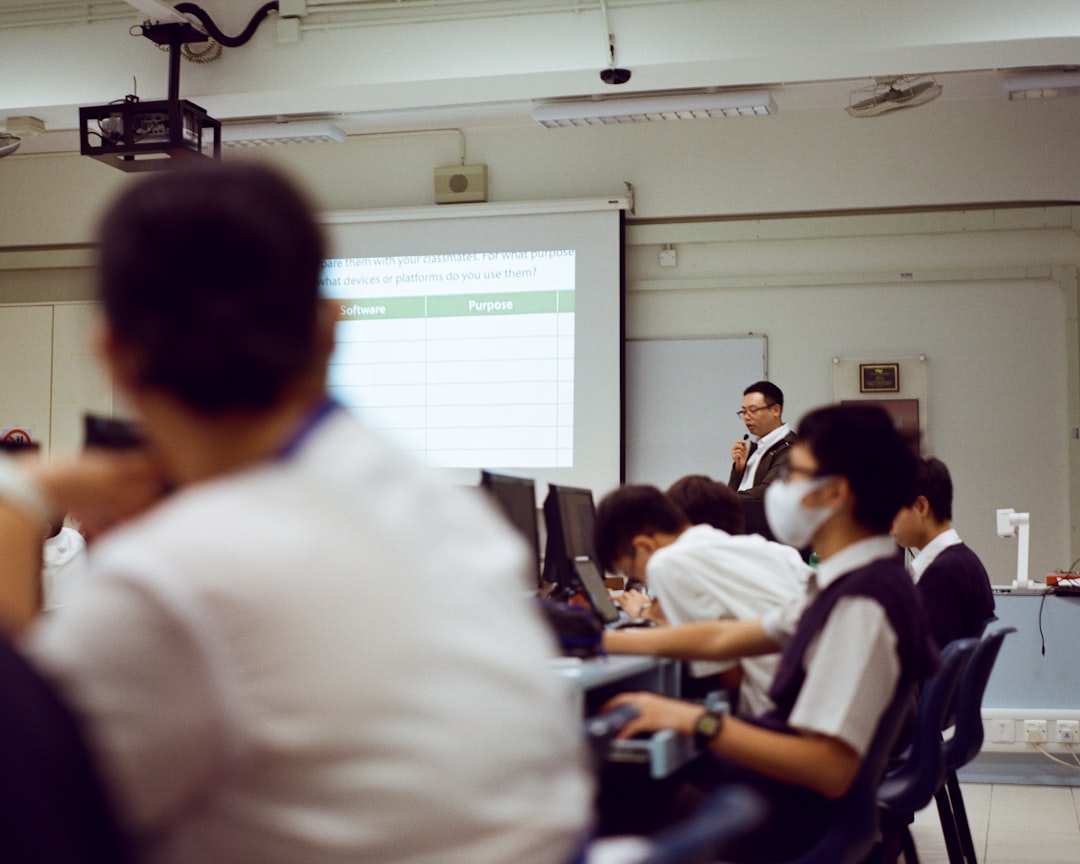 a group of people sitting in front of a projector screen